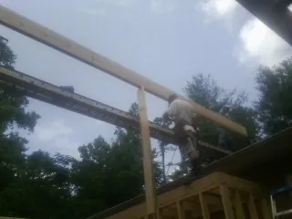 Carpenter setting a ridge beam over a new addition frame — Ice Dam Removal by Roofing Brothers in San Mateo