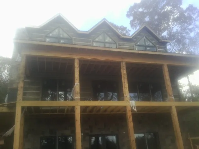 Dormers and porch framing on a large log home under construction — Roof Coating work by our crew in San Mateo