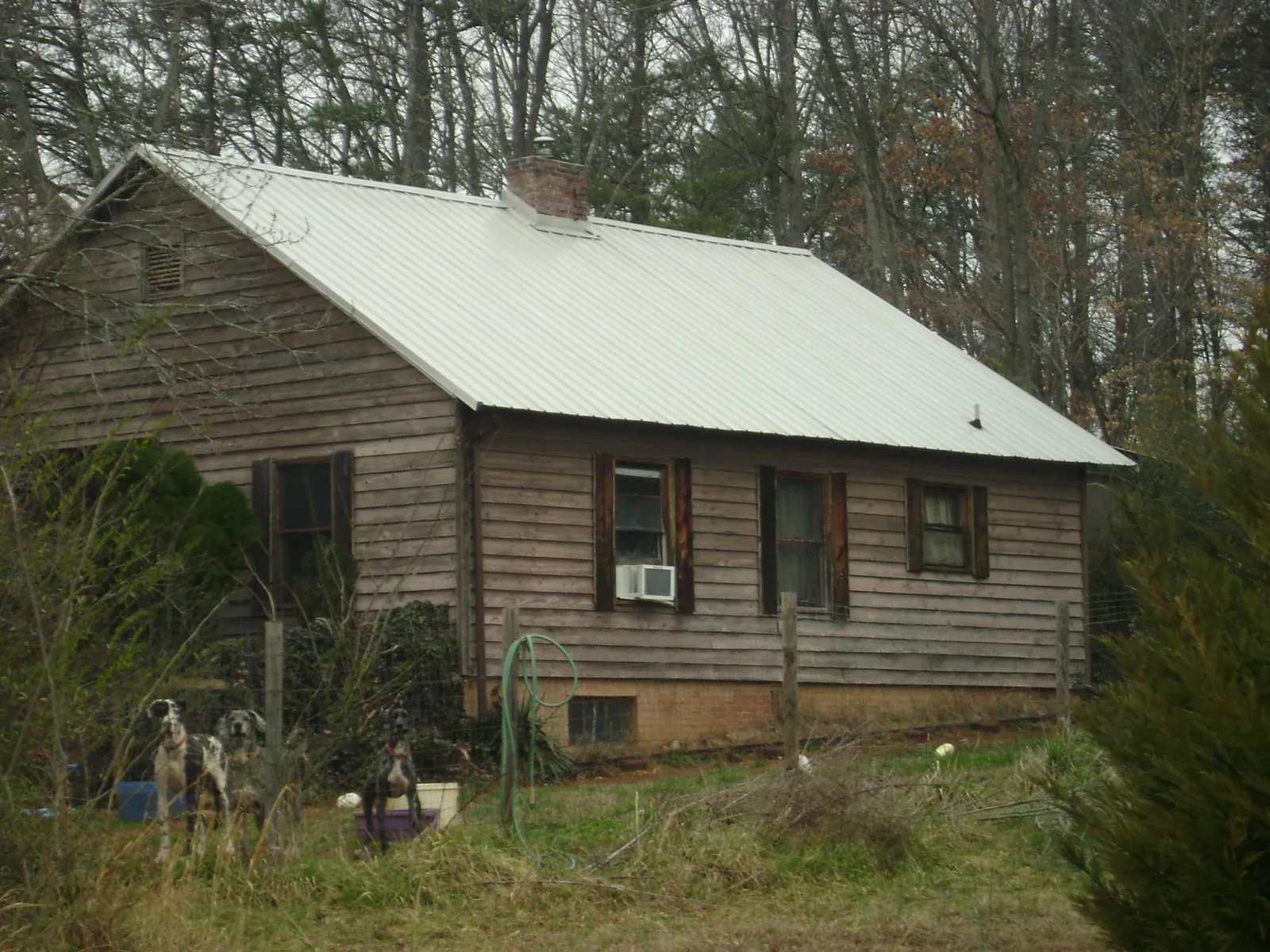 White metal roof on an old wood sided farmhouse, from a Metal Roof Installation job in San Mateo